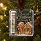 A square clear Christmas ornament hanging from a red ribbon on a Christmas tree. The ornament contains a miniature dollar bill and a gingerbread-themed holiday scene with the text 'A Sweet Little Christmas Surprise.
