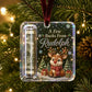 A personalized Christmas ornament hanging on a decorated Christmas tree. The clear square ornament features a printed design with the text 'A Few Bucks From Rudolph' above an illustration of a reindeer wearing a red scarf, a dollar bill roll, snowflakes, and holiday trees.