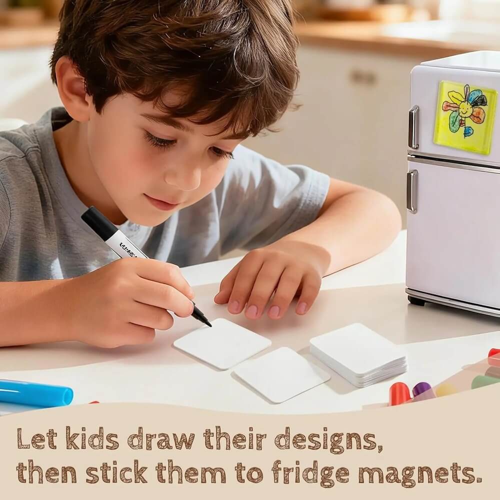 Child drawing on paper with markers, next to a small refrigerator with a magnet on it.