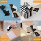 A four-panel collage showing a black and white tape dispenser being used for gift wrapping, home packaging, and office packing. The top-left panel shows the dispenser creating a black paper airplane under the 'Hand Craft' label.