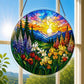A round acrylic suncatcher with a wildflower valley iris lupine tulips and pine trees hanging from a chain in front of a bright white window