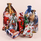 A set of Christmas-themed clear plastic drawstring gift bags with white ribbons, featuring festive holiday illustrations including Santa Claus, reindeer, snowflakes, and stockings, arranged on a solid light beige background.