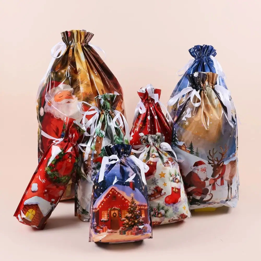 Six Christmas-themed clear plastic drawstring gift bags with white ribbons, decorated with festive illustrations including Santa Claus, reindeer, a Christmas house, and holiday motifs, arranged on a light beige background.