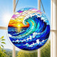 A round acrylic suncatcher with a great wave ocean scene and sunset hanging from a chain in front of a bright white window
