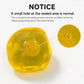 A translucent yellow coconut oil ball on a white background with printed text explaining that a small hole at the sealed area is normal and showing a close-up inset of that hole.