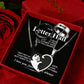 A three-piece metal heart pendant necklace set for couples, displayed inside a red gift box with red roses. The set includes a round pendant engraved with 'I Letter H' and 'To M', a heart-shaped pendant with a cat silhouette and 'I always' text, and a silver ring with a fish skeleton motif.
