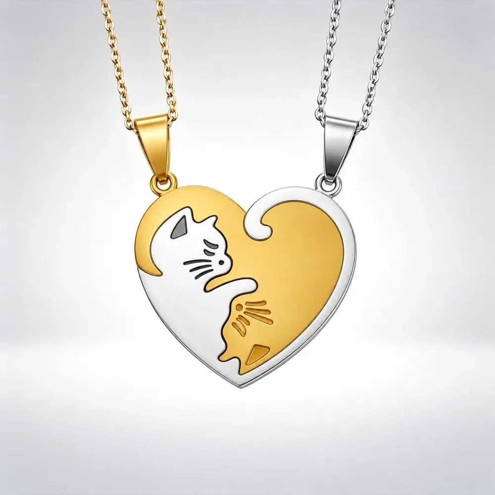 Two heart-shaped pendant necklaces shown side by side, one in gold and one in silver, each featuring a stylized cat and kitten design in the center, suspended on matching chains against a light gray gradient background.