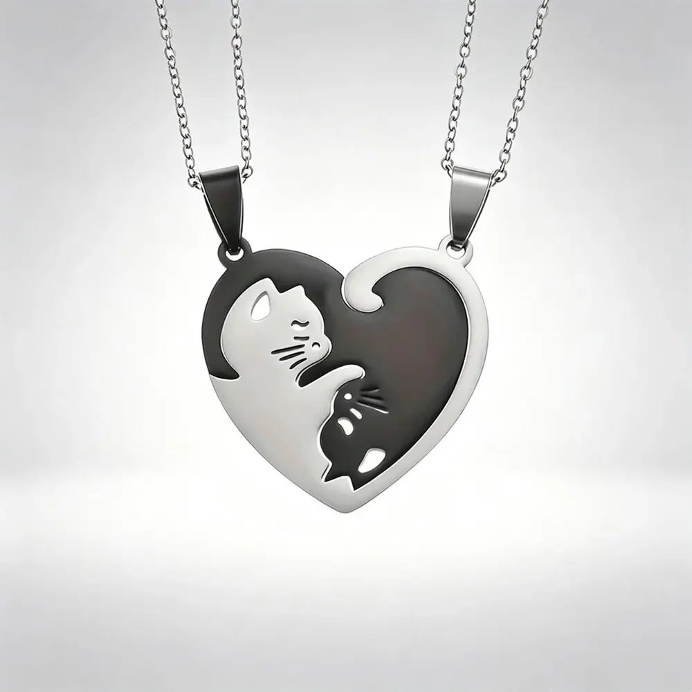 Two matching silver heart-shaped pendant necklaces with cat cutouts, displayed against a light gray gradient background.