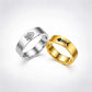 Two metal rings on a light gray background, one silver-toned with a fish symbol and one gold-toned with a fish skeleton symbol.
