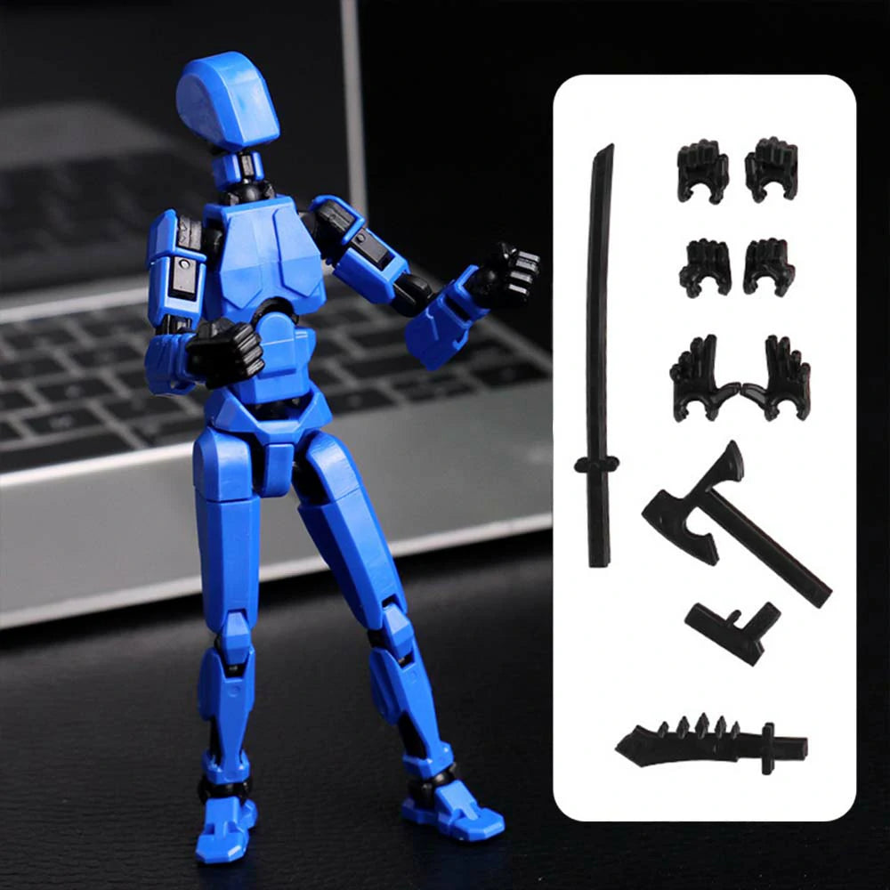 Blue articulated action figure with black accessories, shown standing beside a white panel displaying interchangeable weapon and hand pieces, on a dark tabletop with a blurred laptop in the background.