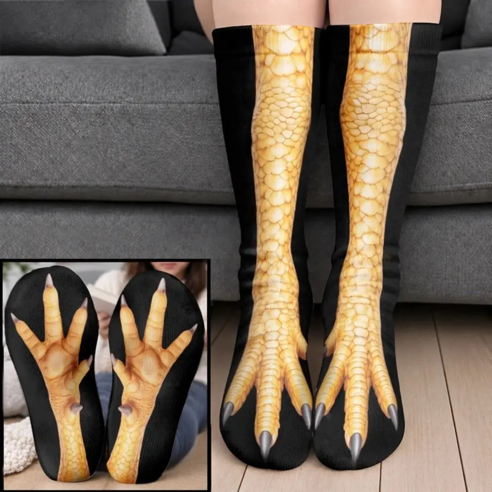 Yellow scaled chicken foot socks with black side panels worn on legs before a gray sofa