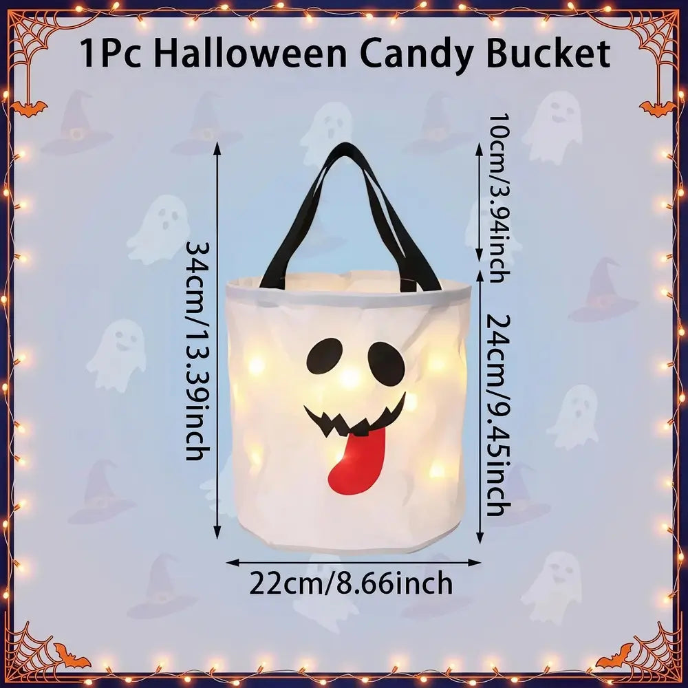 A white Halloween candy bucket with black handles and a ghost face design, shown with overlaid dimensions and text reading '1Pc Halloween Candy Bucket' on a light blue background with ghost and witch motifs.