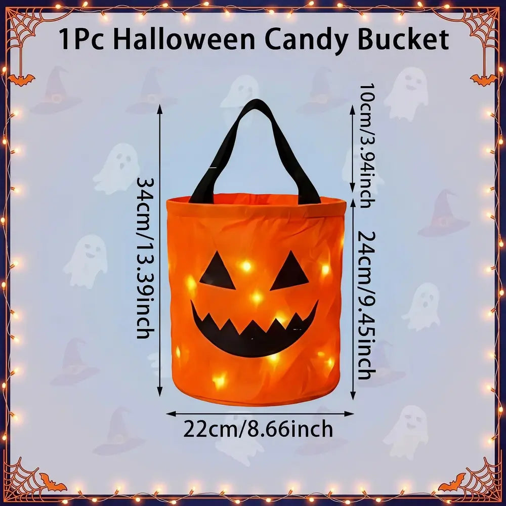 An orange Halloween candy bucket with black handles and a jack-o'-lantern face, shown with dimension labels for height and width on a light blue background with ghost motifs and a decorative border.