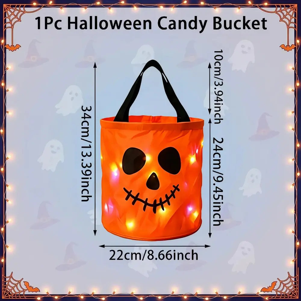 An orange pumpkin-shaped Halloween candy bucket with black handles and a stitched jack-o'-lantern face