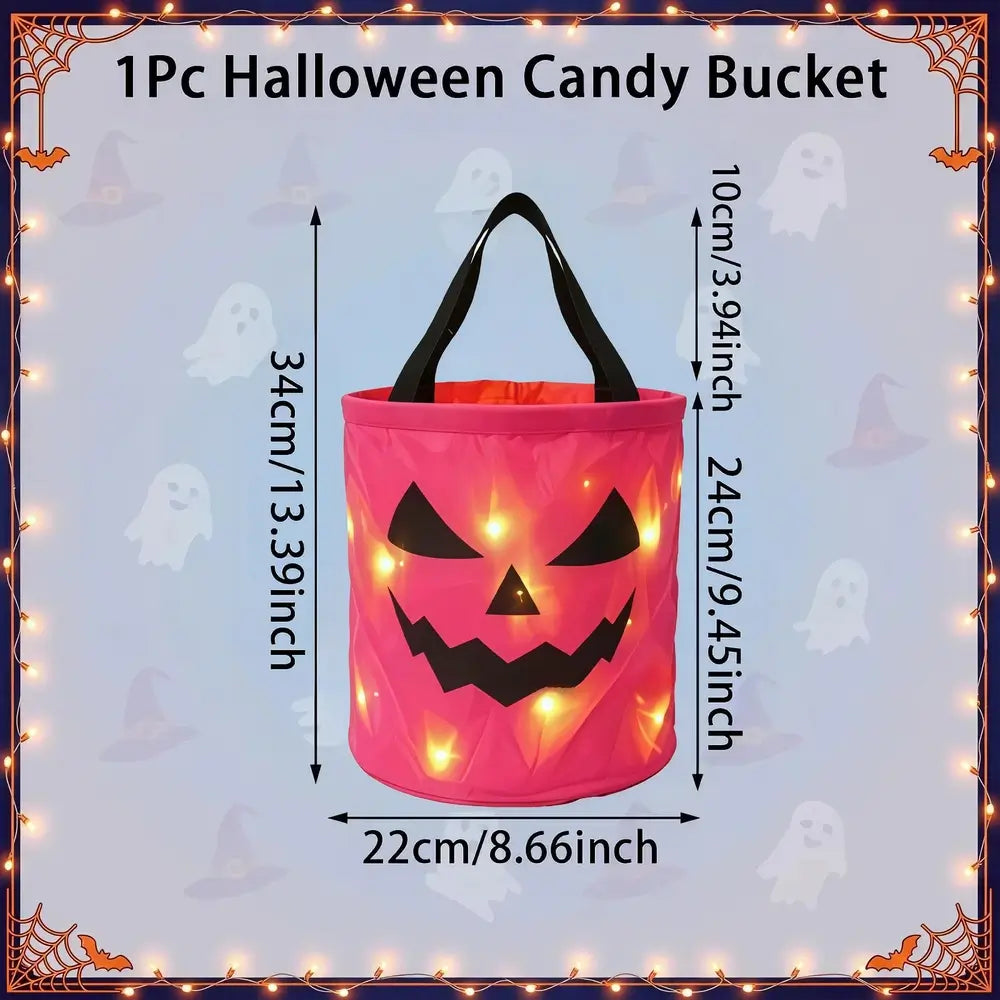 A pink jack-o'-lantern-shaped Halloween candy bucket with black handles, shown with overlaid dimension labels (34cm height, 24cm width, 10cm handle width) and the text '1Pc Halloween Candy Bucket' on a pale blue background with ghost motifs.