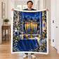 A man holds up the plush white-edged menorah blanket to display its colorful Hanukkah themed print in a bright hallway