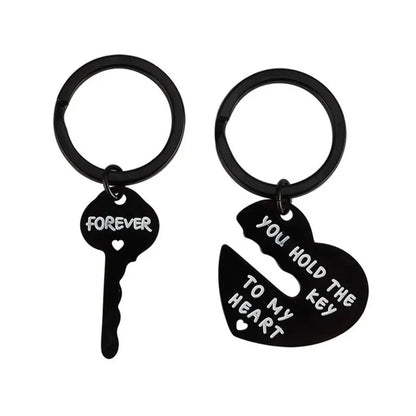 Black key and heart-shaped keychain with engraved text on a white background
