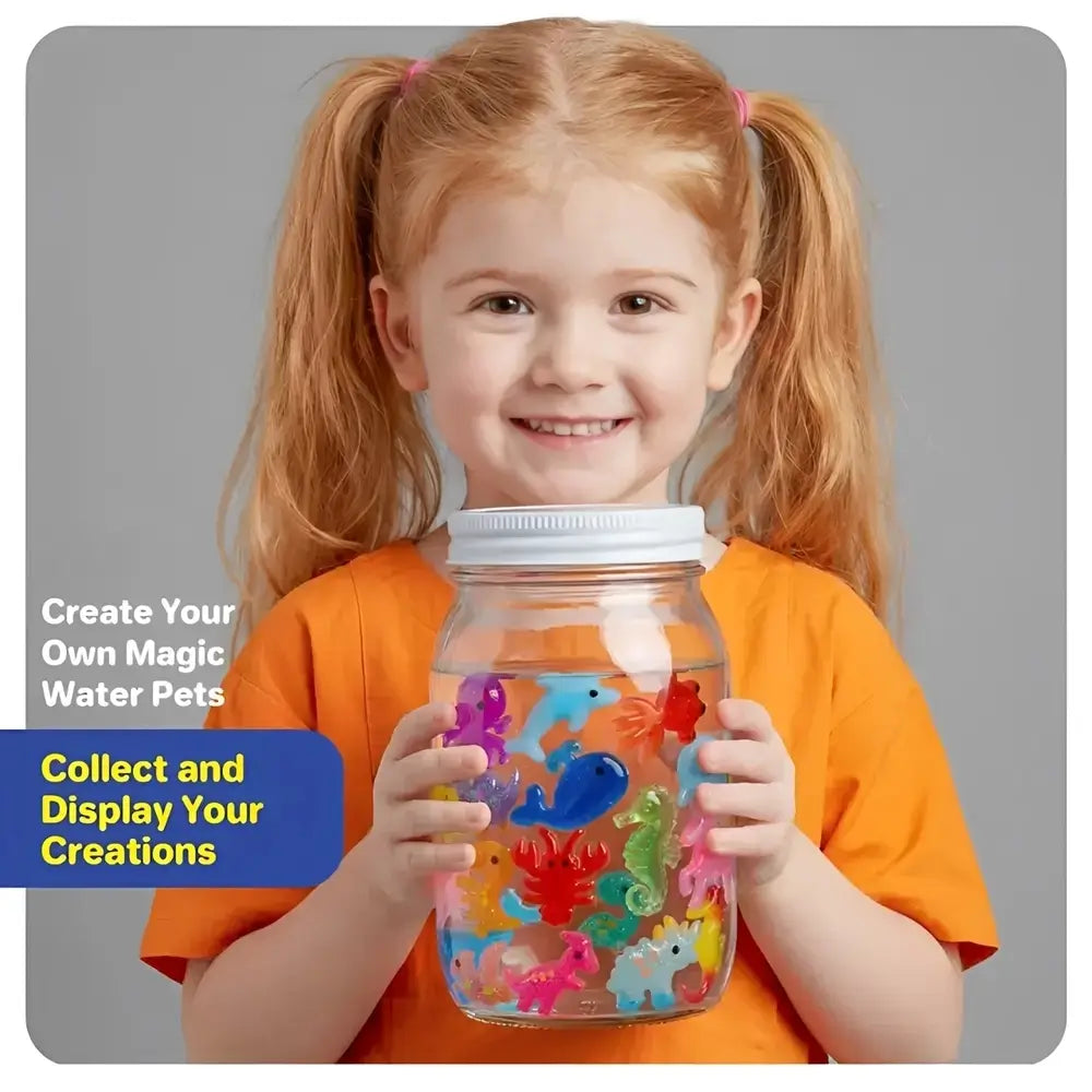 A young girl with blonde pigtails smiles while holding a clear glass jar filled with colorful plastic water-paint fish. The girl wears an orange shirt against a plain gray background, with promotional text on the left reading 'Create Your Own Magic Water Pets' and 'Collect and Display Your Creations.