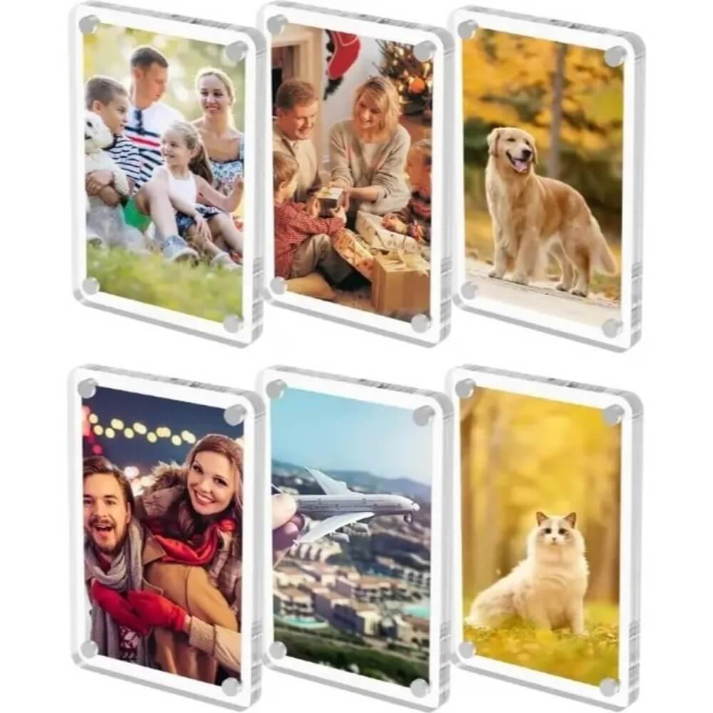 Six clear acrylic photo frames arranged in two rows on a white background, each displaying a different printed photo. The photos include family scenes, a dog, couple portraits, an airplane over a city, and a cat in a yellow field.