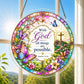 A round acrylic suncatcher featuring the verse with God all things are possible decorated with butterflies and flowers hanging from a chain in front of a bright white window