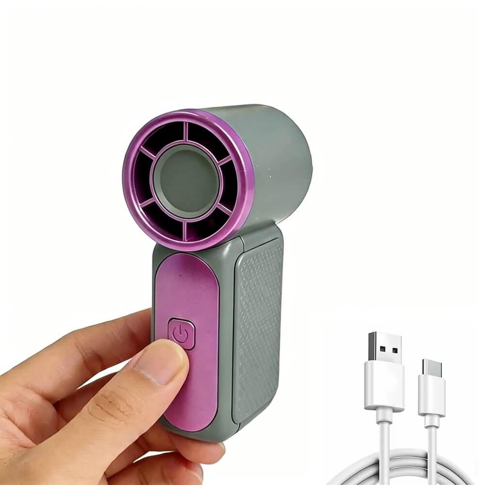 A handheld mini fan with a gray body and purple accents, held by a hand against a white background, with a USB charging cable shown in the lower right corner.