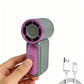 A handheld mini fan with a gray body and purple accents, held by a hand against a white background, with a USB charging cable shown in the lower right corner.
