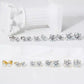 Pair of solitaire moissanite stud earrings displayed with jewelry
