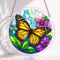 A round acrylic suncatcher with an orange black monarch butterfly beside purple flowers and green leaves