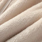 Close-up of a soft plush fabric in a warm off-white or cream color, showing the texture and folds of the material.
