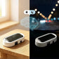 A white rectangular solar-powered car accessory with a black top panel is shown in a split-screen comparison. The left half shows it resting on a wooden table in warm natural light, with glowing circuit-style graphics and sun/moon icons above suggesting smart lighting control.