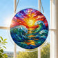 A round acrylic suncatcher with curling turquoise waves beneath a golden sun hanging from a chain in front of a bright white window