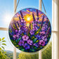 A round acrylic suncatcher filled with purple wildflowers beneath a glowing sunset hanging from a chain in front of a bright white window