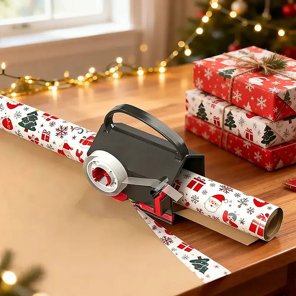 A black and red gift wrap dispenser holding a roll of Christmas-themed wrapping paper on a wooden table, with wrapped presents and warm string lights in the background.